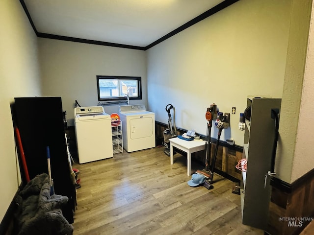 washroom with laundry area, wood finished floors, washing machine and dryer, and crown molding