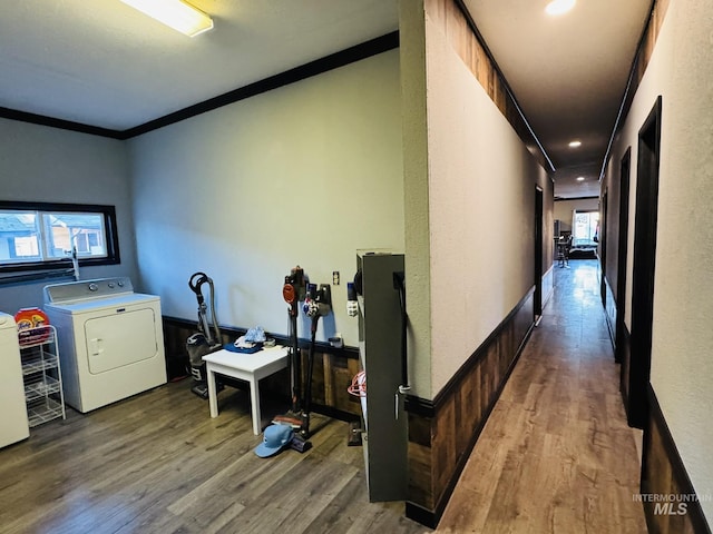 hallway featuring a wealth of natural light, washer and clothes dryer, and wood finished floors