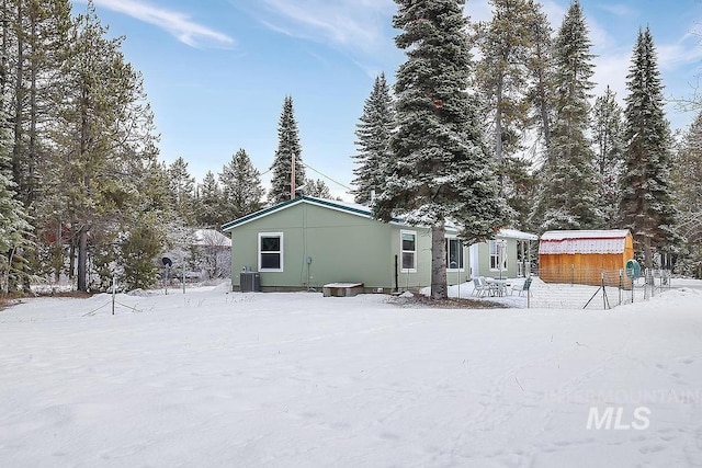 snow covered property featuring central AC