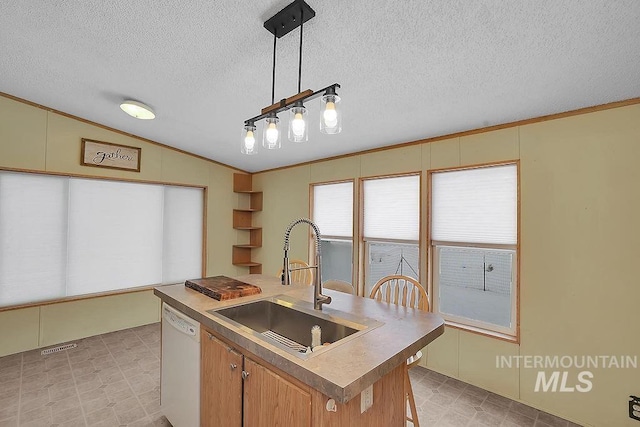 kitchen featuring sink, hanging light fixtures, white dishwasher, vaulted ceiling, and a center island with sink