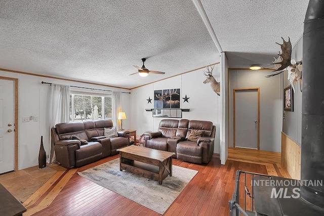 living room with hardwood / wood-style floors, a textured ceiling, and ceiling fan