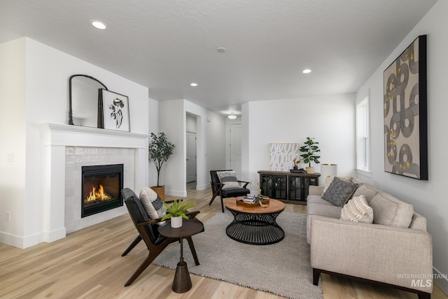 4541 E Fortuna Dr, Nampa, ID 83687 - living area with light wood-style flooring, a tiled fireplace, and recessed lighting