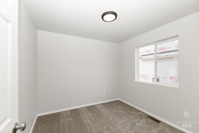 2887 N Rocky Bottom Way, Kuna, ID 83634 - empty room featuring dark colored carpet and baseboards