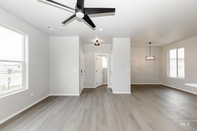 2887 N Rocky Bottom Way, Kuna, ID 83634 - unfurnished living room with light wood finished floors, baseboards, and ceiling fan
