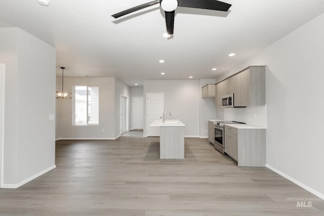 2887 N Rocky Bottom Way, Kuna, ID 83634 - kitchen featuring appliances with stainless steel finishes, baseboards, light countertops, light wood-type flooring, and a sink