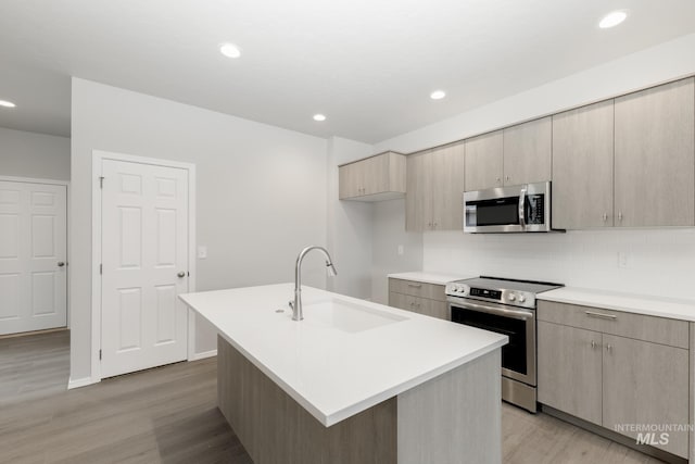 2887 N Rocky Bottom Way, Kuna, ID 83634 - kitchen with appliances with stainless steel finishes, a sink, light wood finished floors, tasteful backsplash, and light countertops