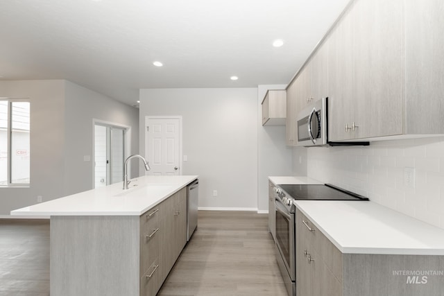 2887 N Rocky Bottom Way, Kuna, ID 83634 - kitchen featuring stainless steel appliances, a sink, light wood-type flooring, modern cabinets, and light countertops