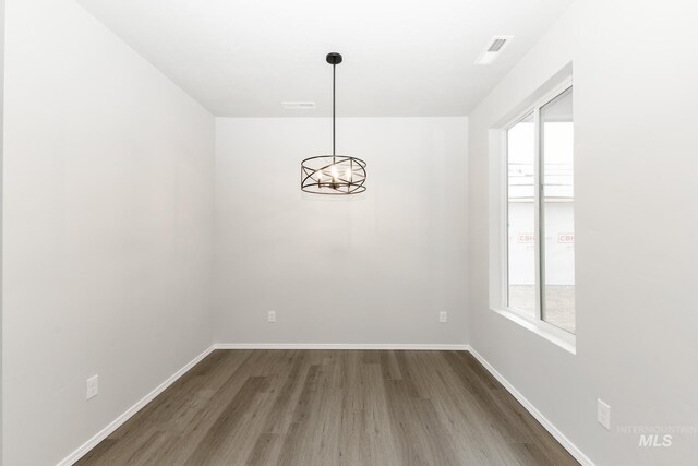 2887 N Rocky Bottom Way, Kuna, ID 83634 - spare room with wood finished floors, a chandelier, and baseboards