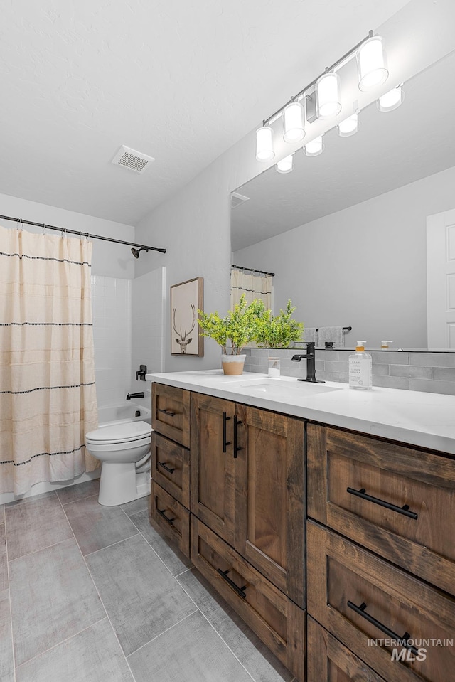 full bathroom featuring toilet, vanity, shower / bath combo with shower curtain, and tile patterned floors