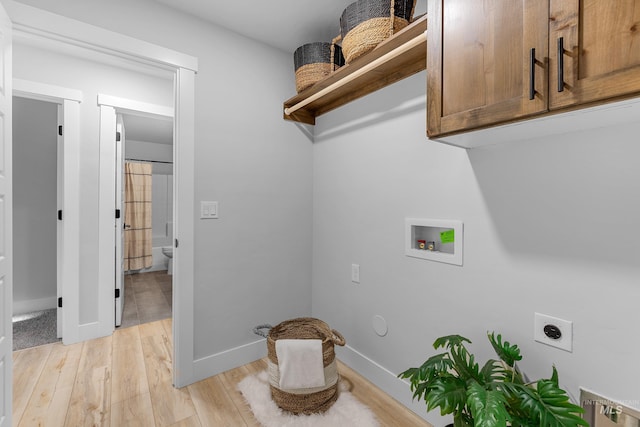 washroom featuring light hardwood / wood-style floors, electric dryer hookup, cabinets, and washer hookup