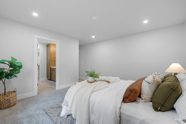 bedroom featuring connected bathroom and light colored carpet