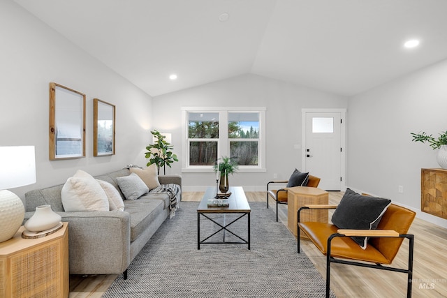 living room featuring light wood-type flooring and vaulted ceiling