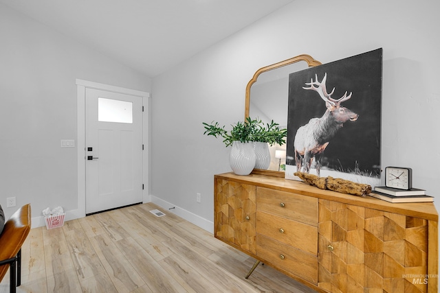 foyer entrance featuring light hardwood / wood-style floors and vaulted ceiling