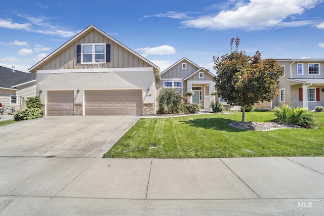 craftsman-style home with board and batten siding, a front yard, driveway, and an attached garage