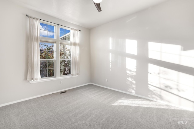unfurnished room featuring baseboards, visible vents, carpet, and a ceiling fan