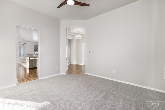spare room with baseboards, carpet, and a ceiling fan