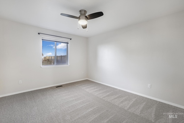 empty room featuring carpet floors, baseboards, ceiling fan, and visible vents