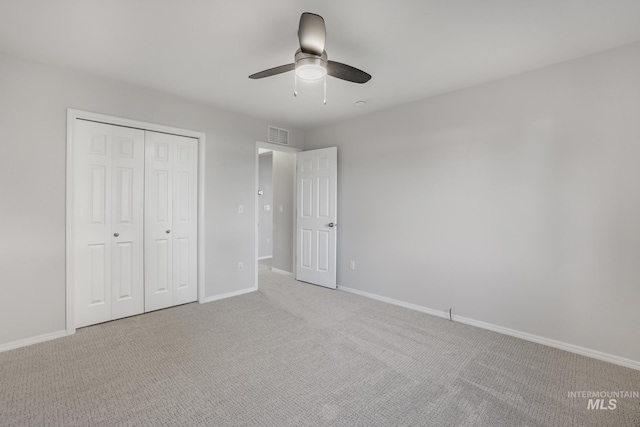 unfurnished bedroom featuring light carpet, baseboards, visible vents, and a closet