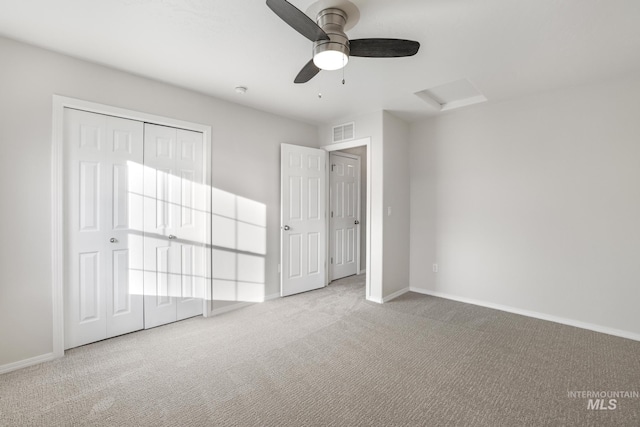 unfurnished bedroom with attic access, baseboards, visible vents, and carpet floors
