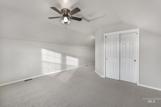 unfurnished bedroom with carpet floors, baseboards, lofted ceiling, and visible vents