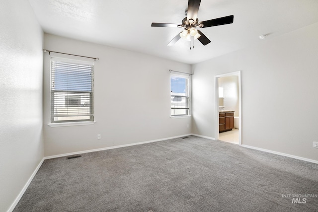 empty room featuring baseboards, visible vents, a ceiling fan, and light colored carpet