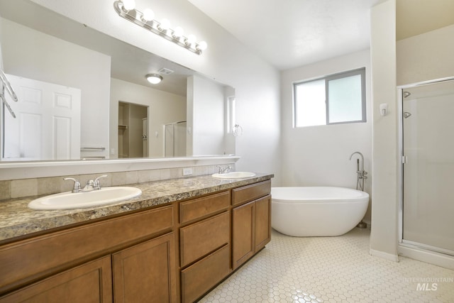 full bath featuring double vanity, a sink, and a shower stall
