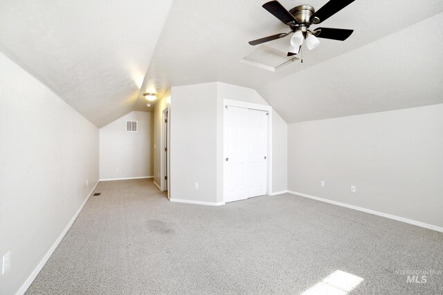 bonus room with baseboards, visible vents, vaulted ceiling, and carpet