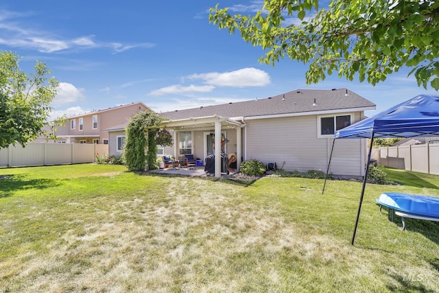 rear view of house with a fenced backyard, a lawn, a patio area, and a trampoline