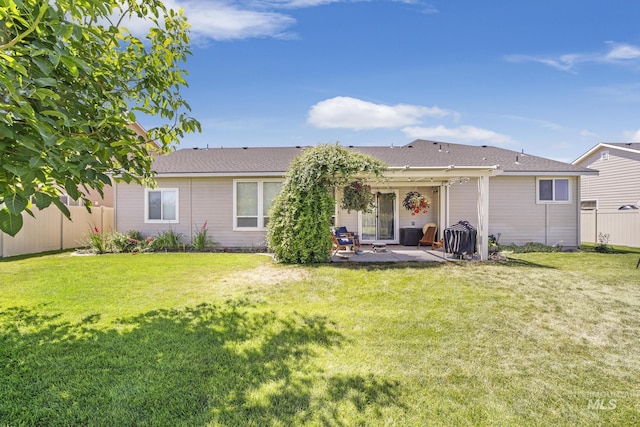back of property with a yard, fence, and a patio area
