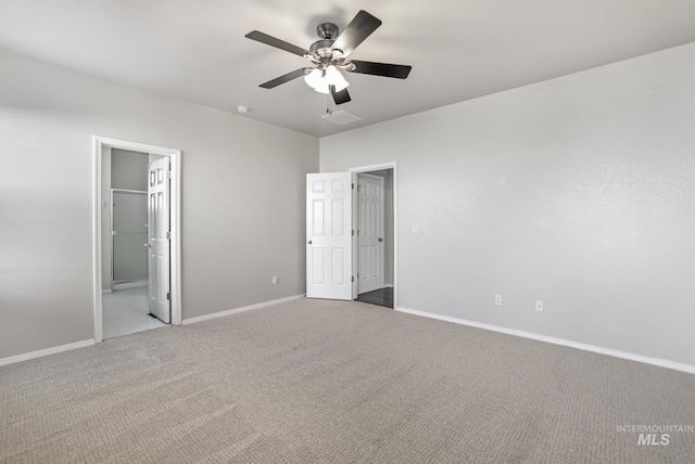 unfurnished bedroom featuring carpet flooring, visible vents, baseboards, connected bathroom, and a ceiling fan