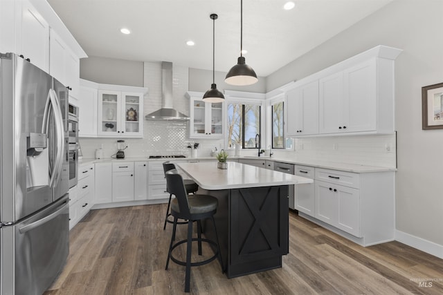 518 Bass Run Ln, Marsing, ID 83639 - kitchen featuring stainless steel appliances, wall chimney exhaust hood, decorative backsplash, a kitchen breakfast bar, and recessed lighting