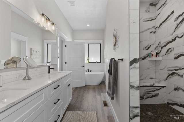 518 Bass Run Ln, Marsing, ID 83639 - full bathroom with a freestanding bath, walk in shower, double vanity, wood finished floors, and decorative backsplash