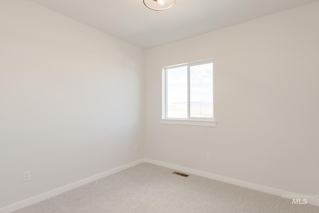 empty room with baseboards, visible vents, and light colored carpet