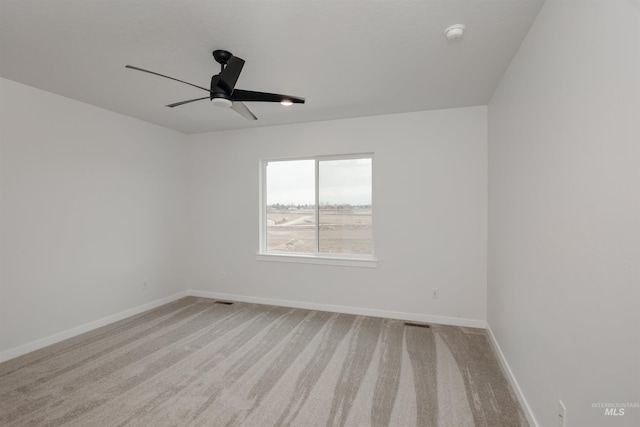 spare room with ceiling fan and light carpet