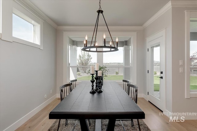 dining room with crown molding, a notable chandelier, and light wood-type flooring