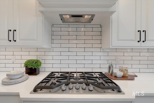 details featuring white cabinets, tasteful backsplash, and stainless steel gas stovetop