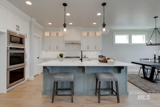 kitchen with white cabinetry, a kitchen island with sink, and appliances with stainless steel finishes