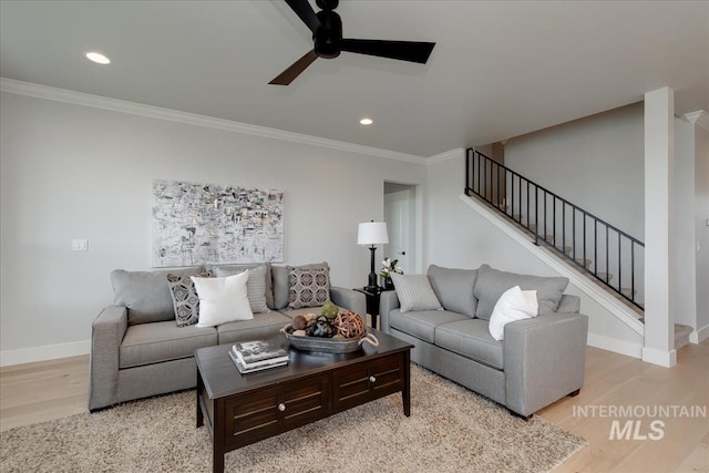 living room with ceiling fan, light wood-type flooring, and ornamental molding