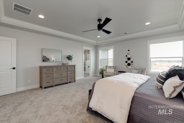 carpeted bedroom featuring a tray ceiling, multiple windows, ceiling fan, and crown molding