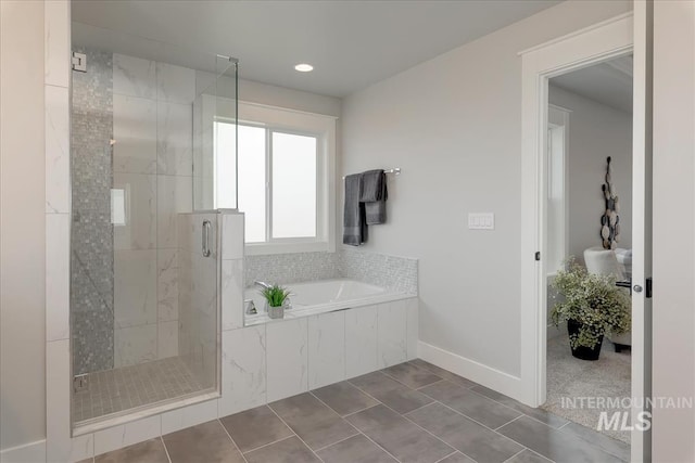 bathroom with tile patterned floors and independent shower and bath