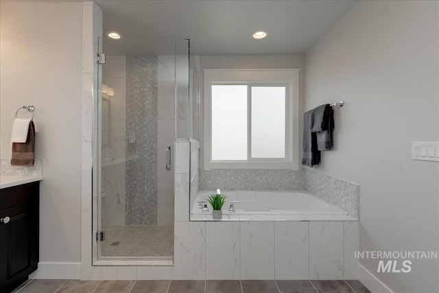 bathroom featuring tile patterned flooring, vanity, and shower with separate bathtub