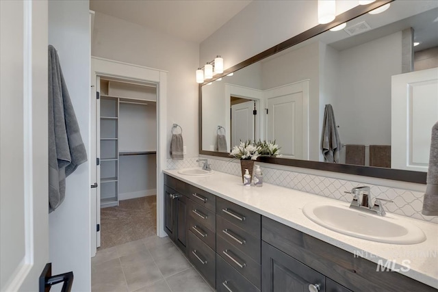 bathroom with decorative backsplash, tile patterned flooring, and vanity