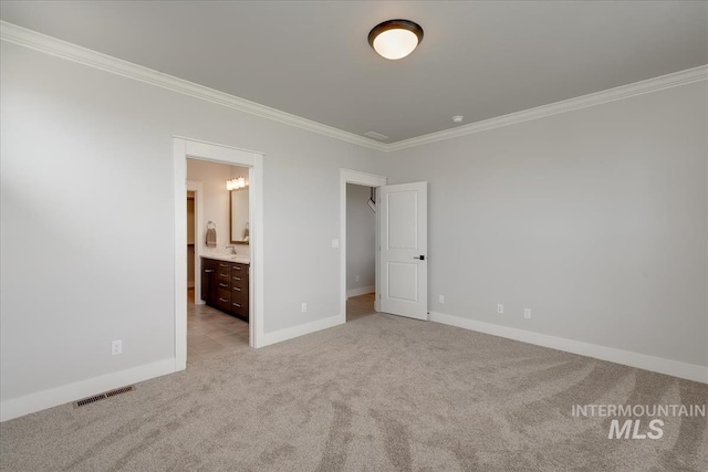 unfurnished bedroom featuring ensuite bathroom, light colored carpet, and ornamental molding