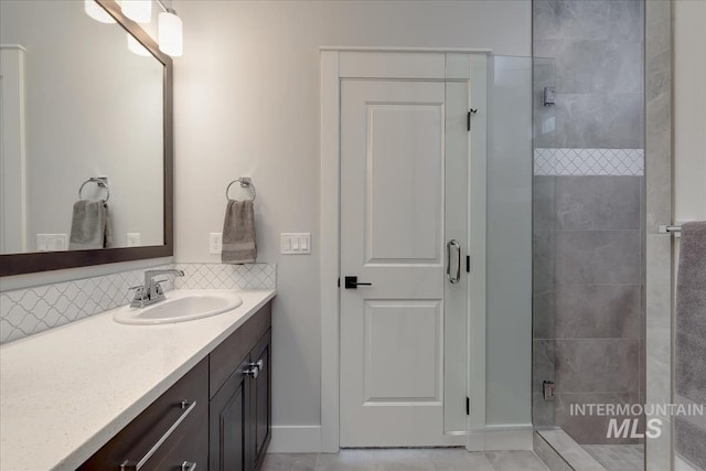 bathroom with vanity, tasteful backsplash, tile patterned floors, and a shower with shower door