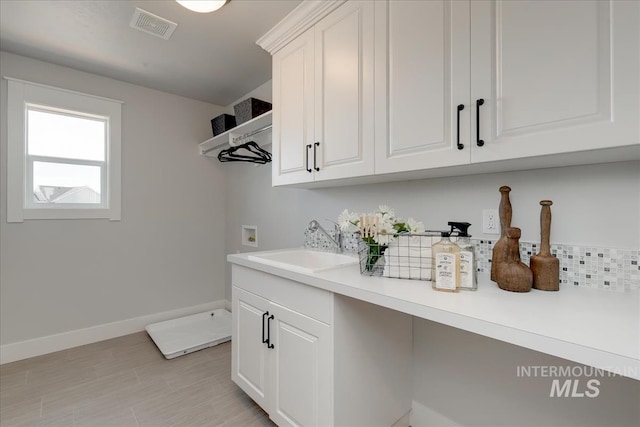 washroom featuring hookup for a washing machine, cabinets, and sink