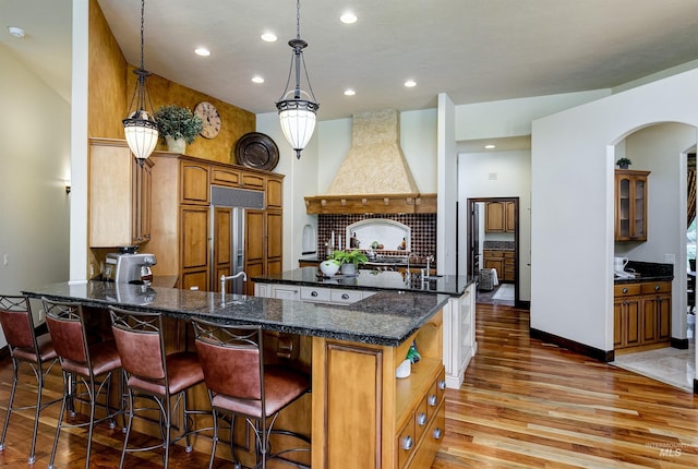 2634 W Sugarberry Dr, Eagle, ID 83616 - kitchen featuring paneled refrigerator, light wood-type flooring, premium range hood, recessed lighting, and a kitchen breakfast bar