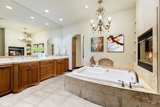 2634 W Sugarberry Dr, Eagle, ID 83616 - bathroom with a chandelier, a tile fireplace, double vanity, a bath, and recessed lighting