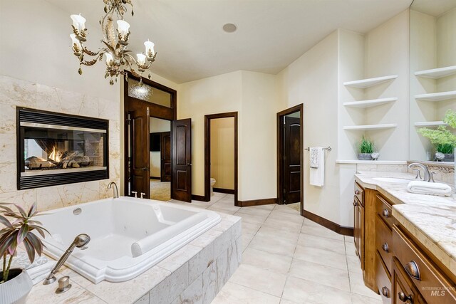 2634 W Sugarberry Dr, Eagle, ID 83616 - bathroom featuring vanity, toilet, a tub with jets, a fireplace, and baseboards
