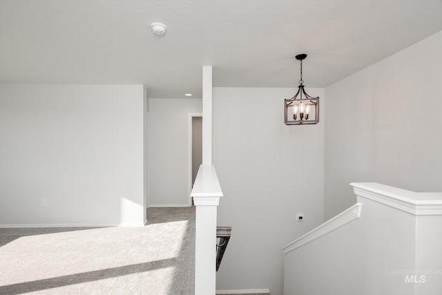 staircase featuring carpet floors and a notable chandelier