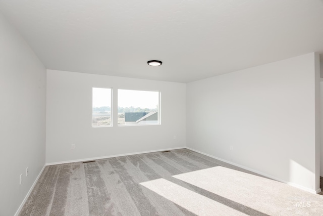 spare room featuring light colored carpet